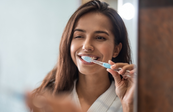Woman with dental implants brushing teeth