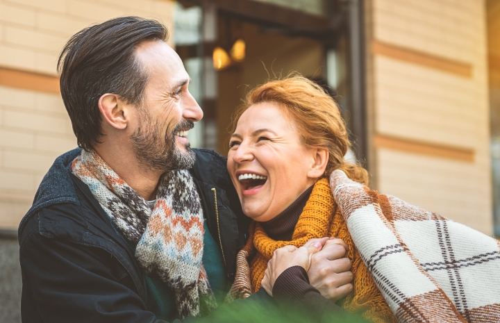 Smiling man and woman enjoying the benefits of getting a dental bridge