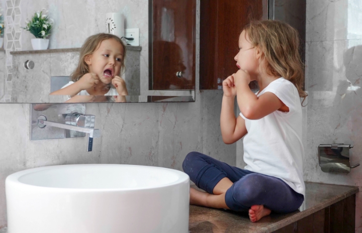 Child looking at smile after children's preventive dental care visit