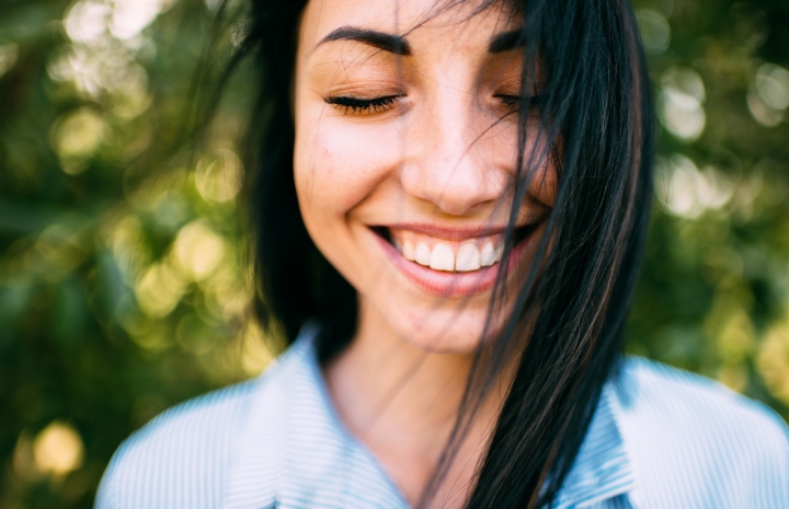 Woman with dental crown smiling outdoors