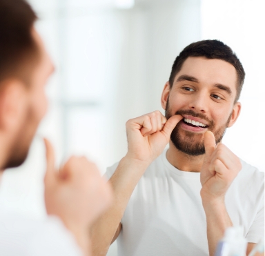 Man flossing after replacing one missing tooth