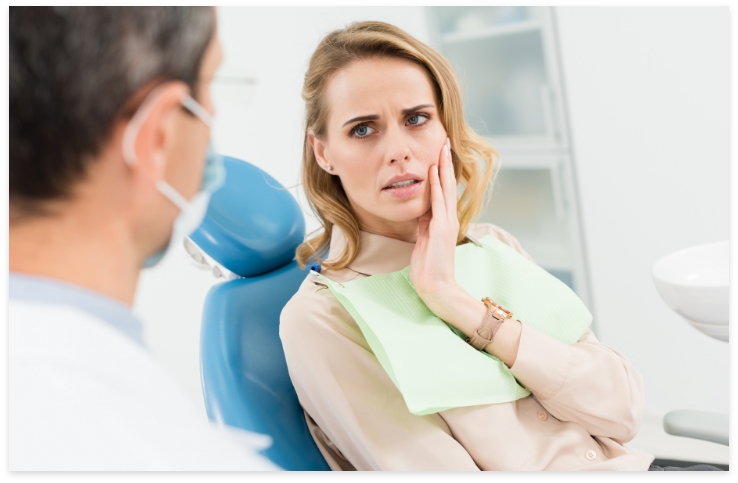 Woman holding cheek before emergency dentistry