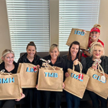 Dental team members holding beach bags