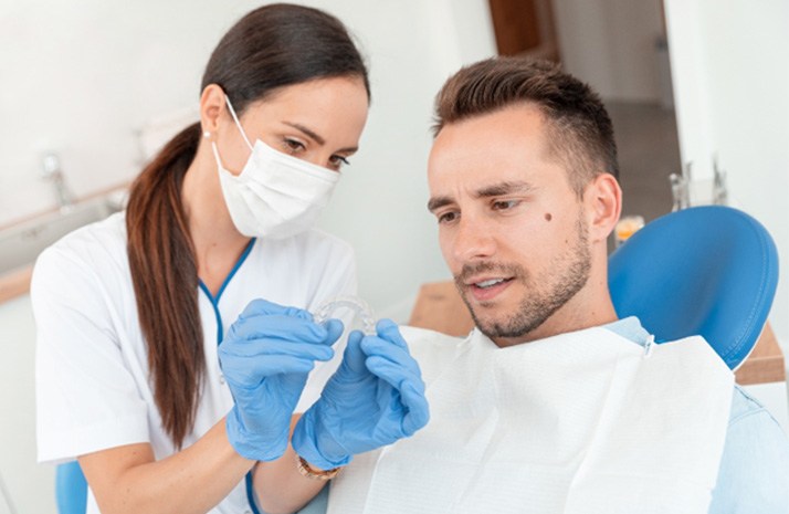 Dentist and patient looking at Invisalign aligner