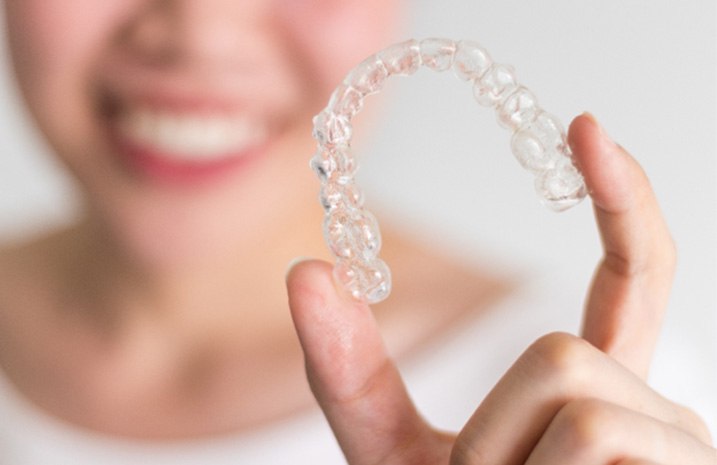 Patient holding Invisalign aligner