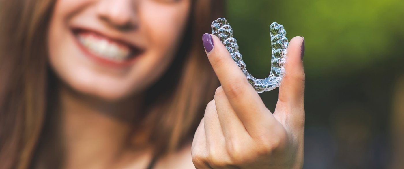 Woman holding an Invisalign tray