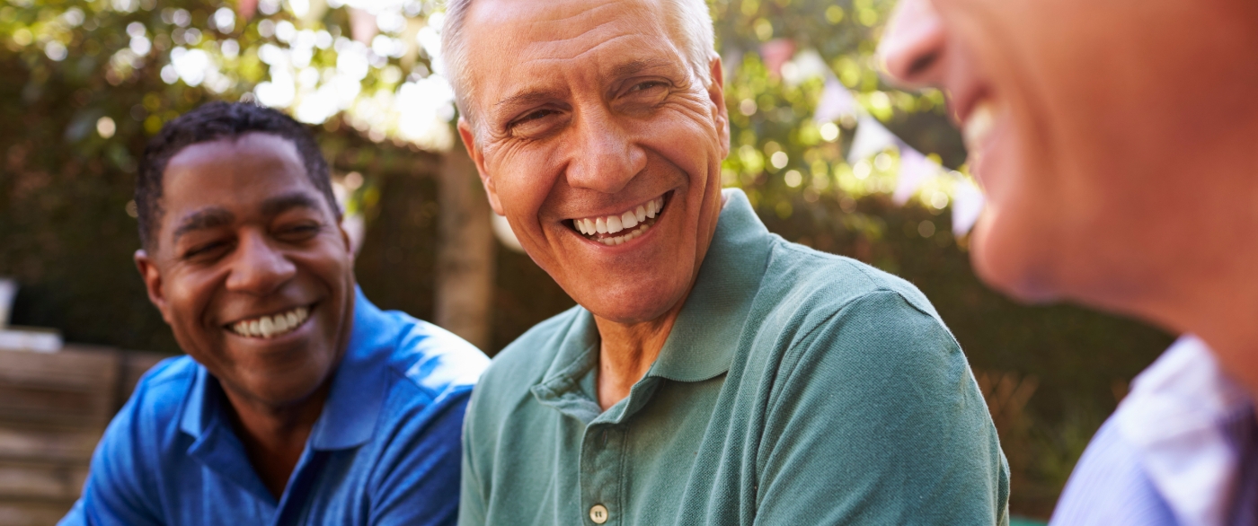 Friends laughing together after replacing missing teeth