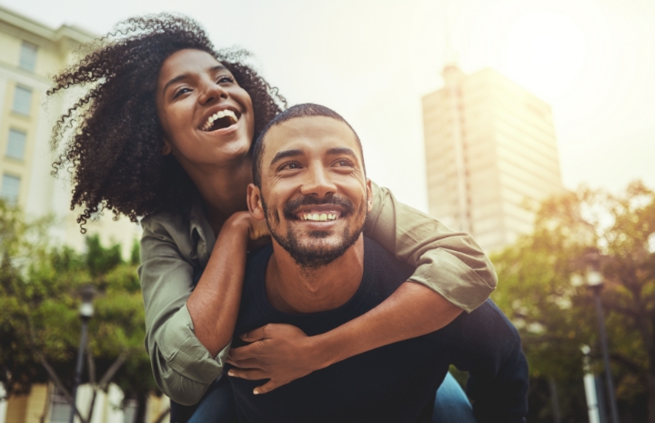 Man and woman with dental crowns smiling outdoors