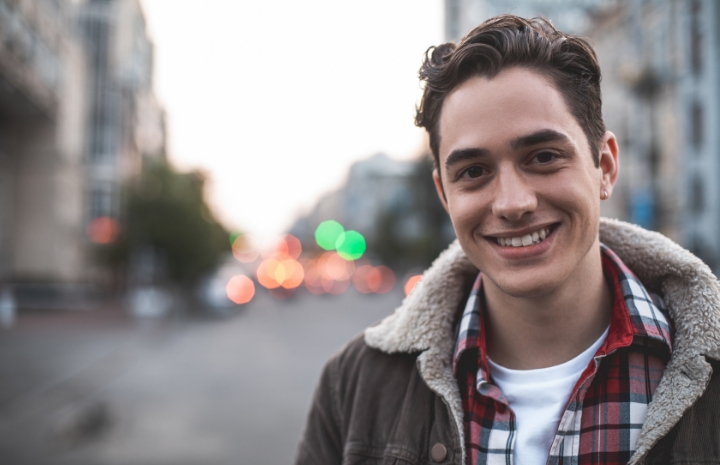 Young person smiling after root canal treatment to relieve toothache pain