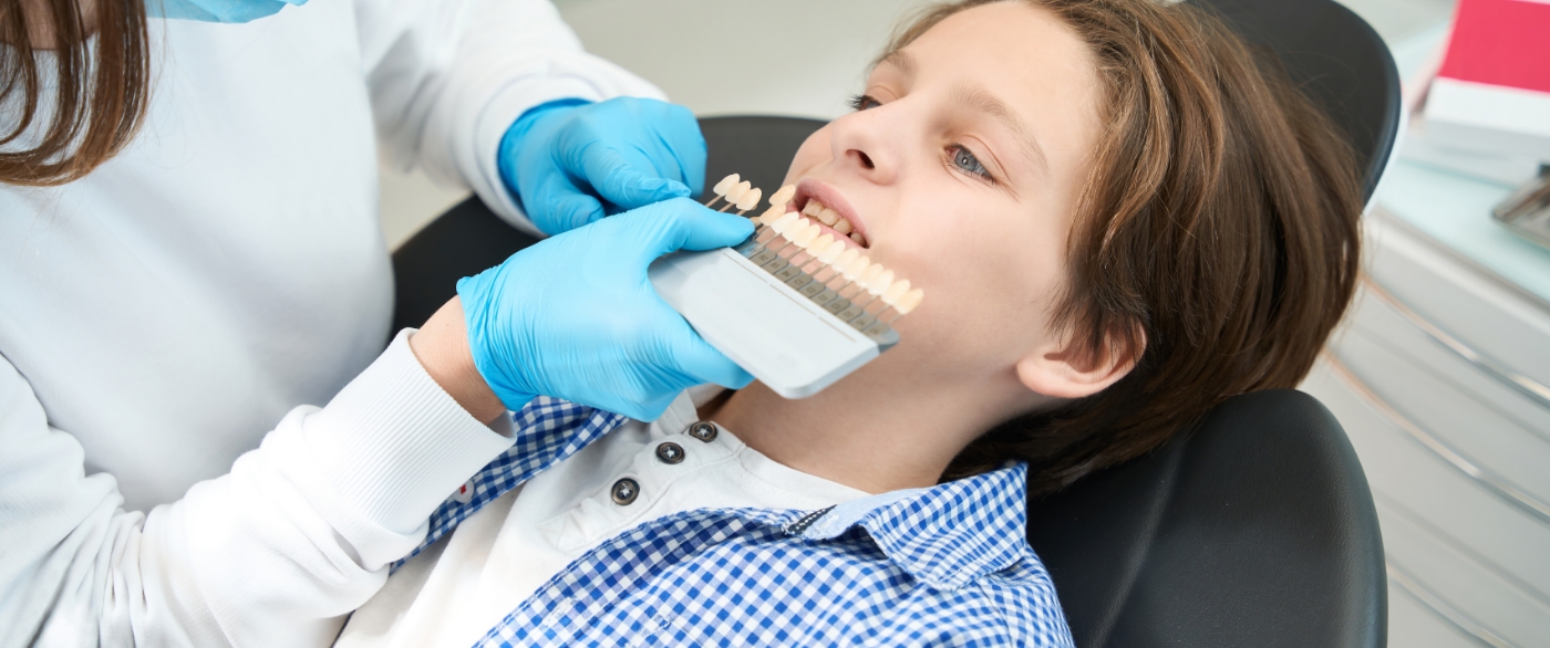 Child's smile compared to color chart before tooth colored filling placement