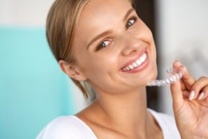 Woman holding Invisalign aligner