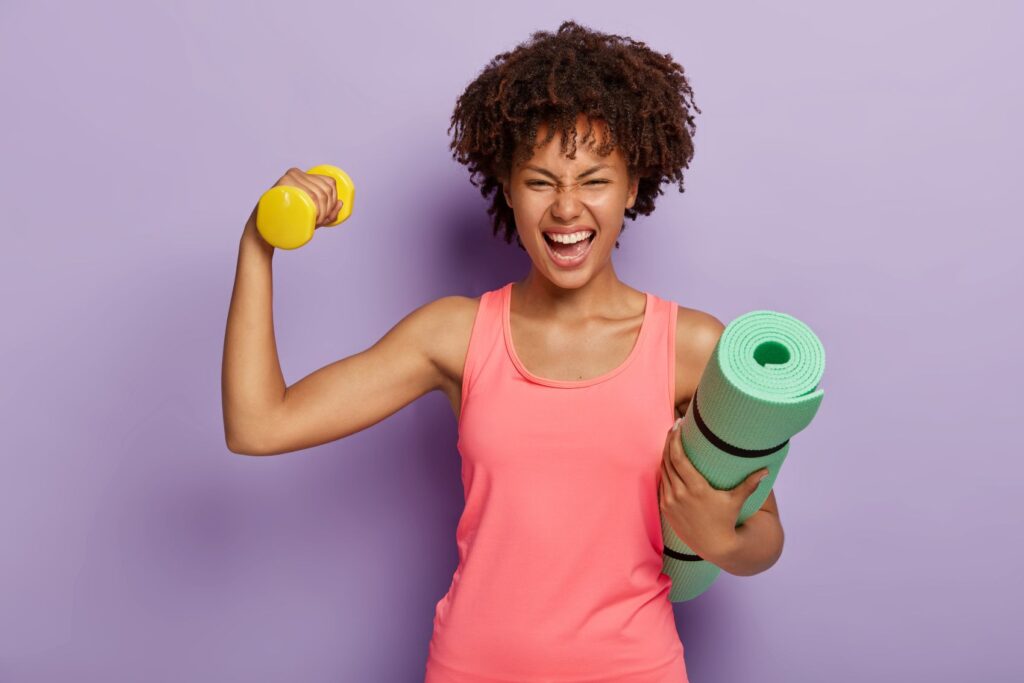 A woman in workout clothing flexing her bicep